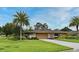 Charming single-story home featuring a well-manicured lawn and lush landscaping with a palm tree at 2900 Cullen Lake Shore Dr, Belle Isle, FL 32812