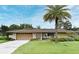 Charming single-story home featuring a well-manicured lawn, lovely landscaping, and a spacious two-car garage at 2900 Cullen Lake Shore Dr, Belle Isle, FL 32812