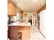 Bright kitchen with wood cabinetry, white appliances, and an adjacent dining area at 2900 Cullen Lake Shore Dr, Belle Isle, FL 32812