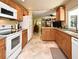 Bright kitchen with tile flooring, wood cabinetry and white appliances at 2900 Cullen Lake Shore Dr, Belle Isle, FL 32812