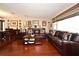 Inviting living room featuring hardwood floors, comfortable leather sofas, and a bright window at 2900 Cullen Lake Shore Dr, Belle Isle, FL 32812