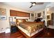 Comfortable main bedroom featuring hardwood floors, a ceiling fan, and an en-suite bathroom at 2900 Cullen Lake Shore Dr, Belle Isle, FL 32812