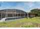 View of screened-in pool and patio area surrounded by green grass and landscaping at 2900 Cullen Lake Shore Dr, Belle Isle, FL 32812