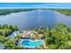 Aerial view of the community featuring a pool, sandy beach, lake and lush greenery at 304 Rum Run # 304, Davenport, FL 33897