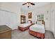 Bright bedroom with two twin beds, rattan furniture, ceiling fan, and tiled floor at 304 Rum Run # 304, Davenport, FL 33897