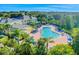 Aerial view of large community pool with lounge chairs and umbrellas surrounded by trees and lush landscaping at 304 Rum Run # 304, Davenport, FL 33897