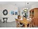 Cozy dining area with modern light fixture, wooden table set for six, and views into the kitchen at 304 Rum Run # 304, Davenport, FL 33897