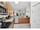 Well-lit kitchen features wood cabinets, stainless appliances, tiled floors, and views into the living area at 304 Rum Run # 304, Davenport, FL 33897