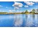 Scenic view of a calm lake surrounded by trees and a blue sky with fluffy clouds at 304 Rum Run # 304, Davenport, FL 33897