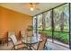 Screened-in patio with table and chairs, showcasing views of lush greenery and landscaping at 304 Rum Run # 304, Davenport, FL 33897