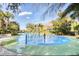 Community splash pad with colorful play structures surrounded by lush landscaping and palm trees at 304 Rum Run # 304, Davenport, FL 33897
