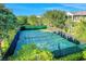 Aerial view of a well-maintained tennis and basketball court surrounded by lush greenery at 304 Rum Run # 304, Davenport, FL 33897