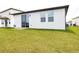 Spacious backyard featuring a sliding glass door and windows overlooking the green lawn at 30498 Pintail Dr, Leesburg, FL 34748