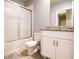 Bathroom featuring a granite countertop, white vanity, and a shower-tub combination with sliding glass doors at 30498 Pintail Dr, Leesburg, FL 34748