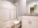 Bathroom view features a granite countertop, white vanity, and a tub-shower with sliding glass doors at 30498 Pintail Dr, Leesburg, FL 34748