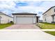 Single-Gathering home with a brick-paved driveway, two-car garage, and well-maintained landscaping at 30498 Pintail Dr, Leesburg, FL 34748