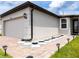 Side view of a well-maintained home with a two-car garage and decorative landscaping at 30498 Pintail Dr, Leesburg, FL 34748