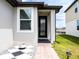 Close-up of a home's front entrance featuring a glass door and decorative landscaping at 30498 Pintail Dr, Leesburg, FL 34748