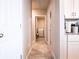 Bright hallway featuring neutral walls, tile floors, and access to the laundry room at 30498 Pintail Dr, Leesburg, FL 34748