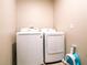 Laundry room with a washer and dryer, featuring a white wall paint and tile flooring at 30498 Pintail Dr, Leesburg, FL 34748