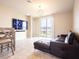 Stylish living room featuring a large television and tile flooring with open access to outdoor patio at 30498 Pintail Dr, Leesburg, FL 34748