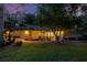 Charming single-story home with well-manicured landscaping, and warm exterior lighting, perfect for evening enjoyment at 311 Needles Trl, Longwood, FL 32779