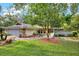 Charming home featuring a stone accent wall on the garage and a lush front yard with mature landscaping at 311 Needles Trl, Longwood, FL 32779