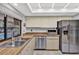 Modern kitchen featuring stainless steel appliances, stone countertops, and a window overlooking the pool at 311 Needles Trl, Longwood, FL 32779