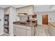 Kitchen with cooktop island and stainless steel double ovens, tile flooring and adjacent dining area at 311 Needles Trl, Longwood, FL 32779