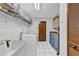 Laundry room with a utility sink and front load washer, complemented by storage shelves and cabinets for organization at 311 Needles Trl, Longwood, FL 32779