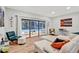Bright living room boasts a sliding glass door with pool views and comfortable white furniture at 311 Needles Trl, Longwood, FL 32779