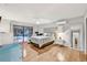 Spacious main bedroom with hardwood floors, ensuite bathroom, and sliding doors to outdoor pool area at 311 Needles Trl, Longwood, FL 32779