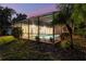 Backyard view with a screened in pool, lush landscaping, and outdoor furniture, perfect for relaxation and entertainment at 311 Needles Trl, Longwood, FL 32779