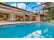Beautiful pool with screen enclosure, outdoor seating, a dining area, and an outdoor bar for entertaining at 311 Needles Trl, Longwood, FL 32779