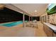 Covered pool area with dining and lounge areas, summer kitchen, and outdoor television at 311 Needles Trl, Longwood, FL 32779