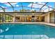 Stunning pool with a screened enclosure, outdoor seating, dining area, and a built-in grill for entertaining at 311 Needles Trl, Longwood, FL 32779