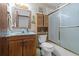 Bathroom with wood vanity, ample lighting and shower with glass doors at 3131 Juniper Dr, Edgewater, FL 32141