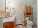 A practical bathroom with a classic vanity, open storage unit, and shower-tub combination at 3131 Juniper Dr, Edgewater, FL 32141