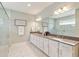 Bathroom featuring double sinks, white cabinets, and a glass enclosed shower with tiled walls at 3397 Sagebrush St, Harmony, FL 34773