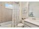 Bright bathroom featuring a shower with a tub, white vanity, and decorative artwork at 3397 Sagebrush St, Harmony, FL 34773