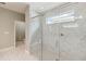 Modern bathroom features a glass-enclosed shower with marble tile and a window for natural light at 3397 Sagebrush St, Harmony, FL 34773