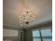 A decorative chandelier is centered above a bedroom with soft green walls and custom shutters at 3397 Sagebrush St, Harmony, FL 34773