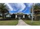 Community clubhouse featuring a welcoming entrance with lush landscaping and palm trees at 3397 Sagebrush St, Harmony, FL 34773
