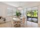 Bright dining area with natural light, slider doors, stylish light fixture, and tile flooring at 3397 Sagebrush St, Harmony, FL 34773