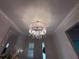 Elegant foyer showcasing a drum chandelier with crystal accents and decorative trim at 3397 Sagebrush St, Harmony, FL 34773