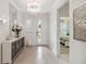 Bright foyer with a chandelier and mirrored console table upon entry at 3397 Sagebrush St, Harmony, FL 34773