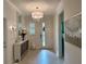Elegant foyer with stylish light fixture, decorative mirror and bright front door at 3397 Sagebrush St, Harmony, FL 34773