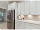 Bright kitchen with white cabinets, stainless steel appliances, and herringbone backsplash at 3397 Sagebrush St, Harmony, FL 34773