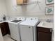 Bright laundry room with updated machines, countertop, sink, and ample shelving at 3397 Sagebrush St, Harmony, FL 34773