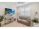 Cozy living room with stylish decor, comfortable sofa, and a mounted TV at 3397 Sagebrush St, Harmony, FL 34773